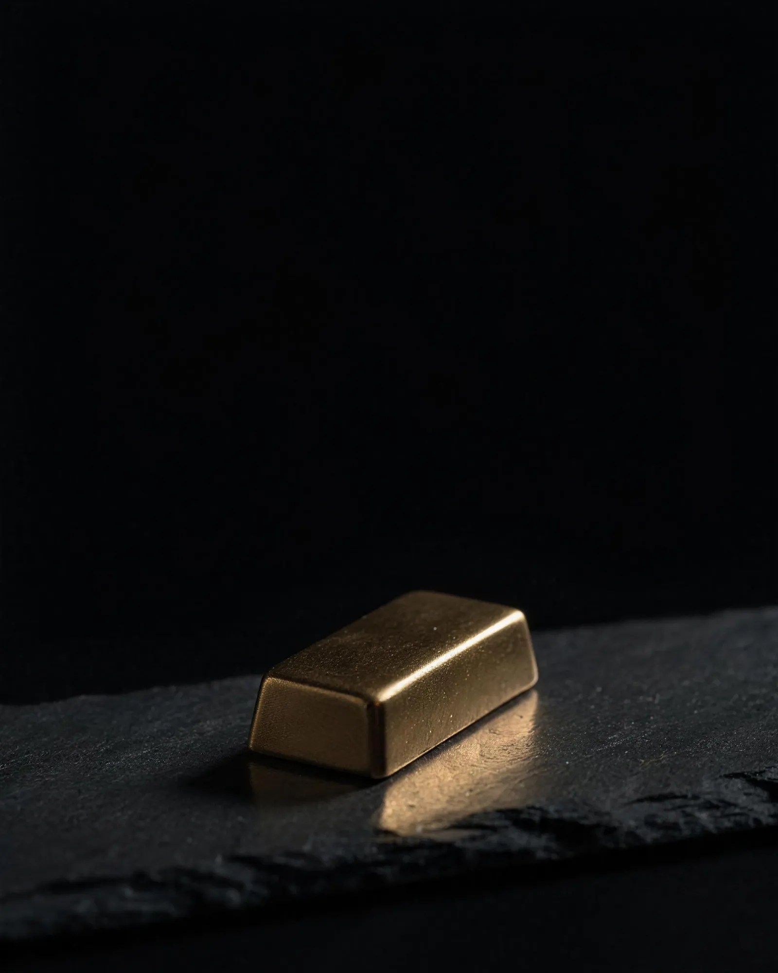 Goldbarren auf dunklem Schiefer